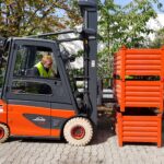 Dieter Thoma sitting in red lime forklift three red boxes