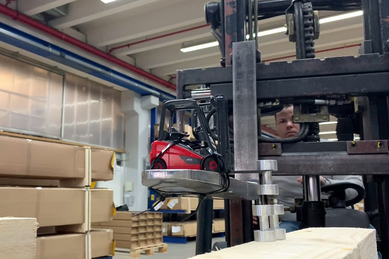 scene from winner video by guiseppe tamburino big lime tree forklift lifts up toy forklift