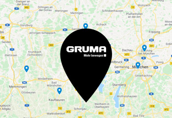 Black location sign on card with the inscription GRUMA Move more