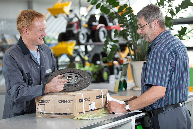 GRUMA Landtechnik salesman hands out agricultural machinery spare parts to customers