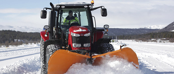 Schmidt Winterdiensttechnik Schneepflug an rotem Traktor