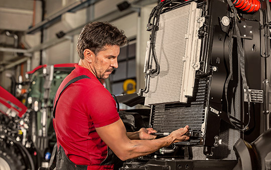 Case IH service technician attaching a spare part for agricultural machinery