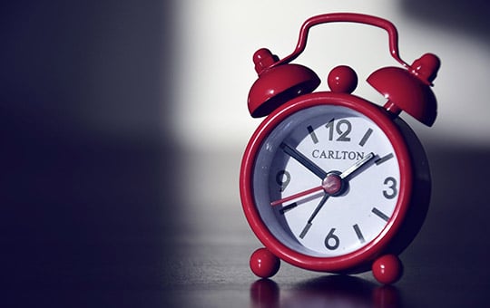 Red alarm clock shows time