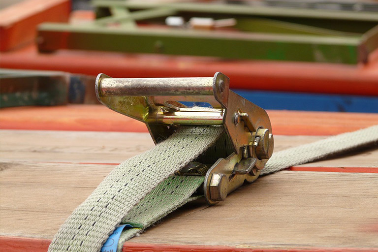 Lashing strap secures load on bench
