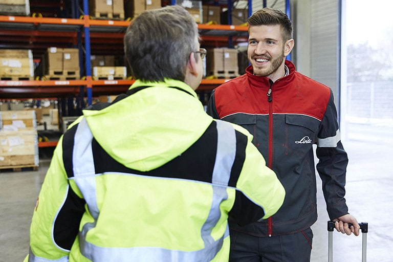 Header service technician greets customers for forklift service