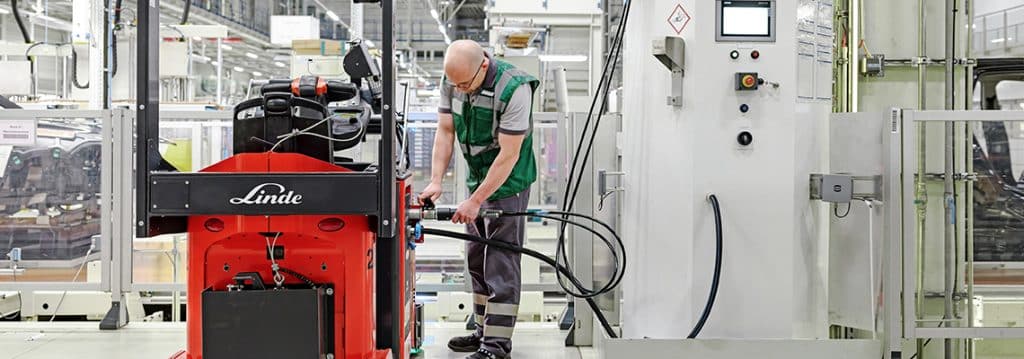 Man refuels AGV from Linde with hydrogen