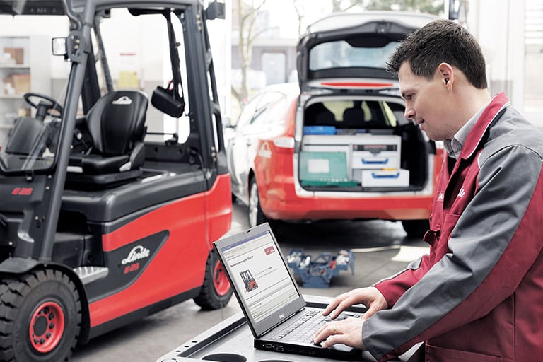 Technician performs tests on the forklift with laptop